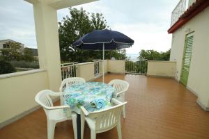 stół i krzesła z parasolem na balkonie w obiekcie Apartment Labin 7468a w mieście Labin