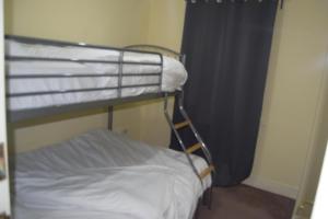 a bunk bed in a small room with a bunk bedutenewayangering at Remarkable 2-Bedroom Apartment with an EnSite in London