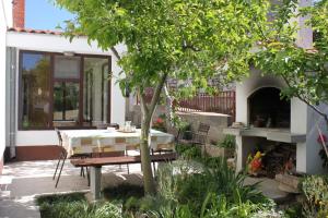 a table and chairs in a garden with a tree at Apartments with a parking space Vodice - 7604 in Vodice