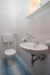 a white bathroom with a toilet and a sink at Apartments with a parking space Vodice - 7604 in Vodice