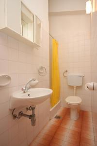 a bathroom with a sink and a toilet at Apartments with a parking space Vodice - 7604 in Vodice