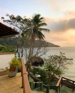 a balcony of a house with a view of the ocean at Pousada Canto do Mar Ilha Grande in Praia de Araçatiba