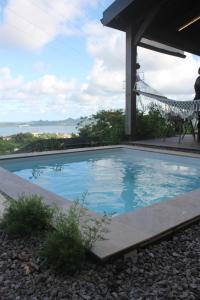 a swimming pool with a chair next to it at Lodges Mont-Vert in Le Robert