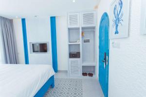 Zimmer mit einem Bett und einem Surfbrett in der Unterkunft SUNTORINI BOUTIQUE HOTEL in Vũng Tàu