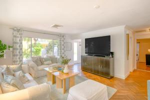 een woonkamer met witte meubels en een flatscreen-tv bij Sensational Seaside Home in Fort Lauderdale