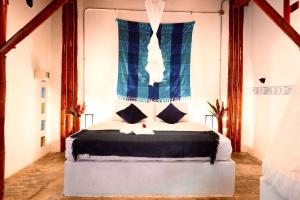 1 dormitorio con 1 cama y ventana azul en Kanta Sana, en Palomino