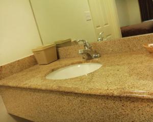 a bathroom counter with a sink and a mirror at Maverick Inn in Eagle Pass