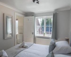 a bedroom with a white bed and a window at Chapel Break, 2 Bed, 2 Bathroom House With Parking & Fast Wifi in Norwich