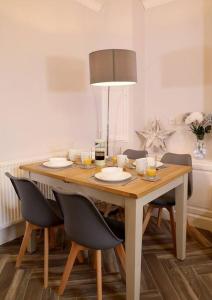 einen Esstisch mit Stühlen und einer Lampe in der Unterkunft Yoxford House, Ginger & Gold Ltd in Norwich