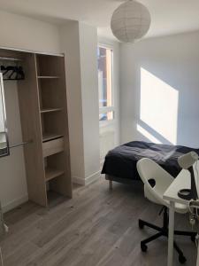 1 dormitorio con cama, escritorio y silla en Évry time, en Courcouronnes