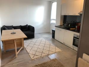 a living room with a table and a kitchen at Évry time in Courcouronnes