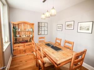 uma sala de jantar com uma mesa de madeira e cadeiras em Alpen Rose Cottage em Portland