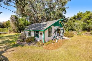 a small green and white house in a yard at Mendocino Dunes - Dune Flower in Fort Bragg