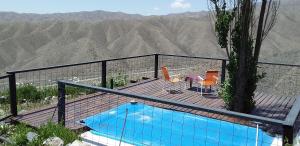 a swimming pool on a deck with a view of the mountains at La Nave del Olvido- Cabaña Potrerillos in Potrerillos