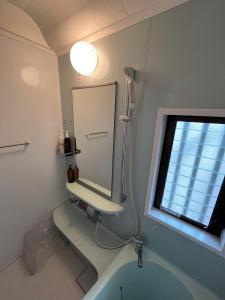 un baño con espejo y lavabo en Villa KUMANO, en Hongū