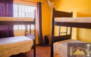 a room with two bunk beds and a window at Hostal Alabalti in San Pedro de Atacama