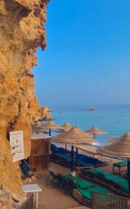 ein Strand mit Sonnenschirmen und Stühlen und das Meer in der Unterkunft Sunset Hotel sharm El Sheikh in Sharm El Sheikh