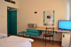 a bedroom with a desk with a television and a bed at Sunset Hotel sharm El Sheikh in Sharm El Sheikh