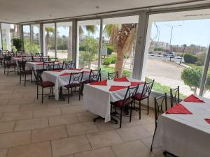 Sunset Hotel sharm El Sheikh في شرم الشيخ: مطعم بطاولات وكراسي بمناديل حمراء