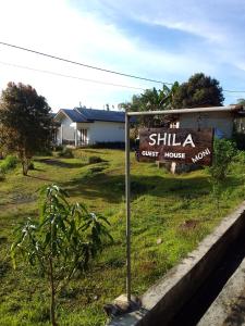 un cartel que dice shilla casa de huéspedes en un campo en SHILA GUEST HOUSE, en Kelimutu