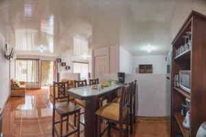 a kitchen and living room with a table and chairs at Cabañas del Rio in Fortuna
