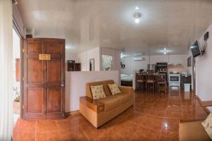 a living room with a couch and a kitchen at Cabañas del Rio in Fortuna