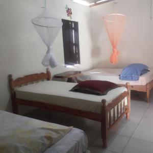 two twin beds in a room with a window at Finca Fuente de Vida in Estelí
