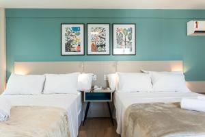 Apartamento em Hotel Beira Mar de Boa Viagem في ريسيفي: سريرين في غرفة فندق بجدران زرقاء