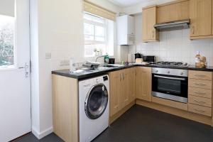 a kitchen with a washing machine and a sink at Stafford Rest Ginger & Gold Ltd in Norwich