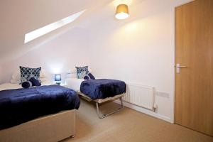 1 dormitorio con 2 camas, ventana y puerta en Stafford Rest Ginger & Gold Ltd en Norwich
