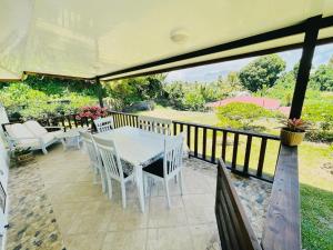 a patio with a table and chairs on a deck at KIANI HOME in Afaahiti