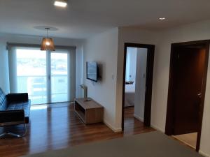 een woonkamer met een bank en een kamer met een bed bij Departamentos DSM in Necochea