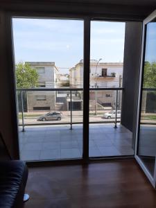 een kamer met een groot raam met uitzicht op een straat bij Departamentos DSM in Necochea