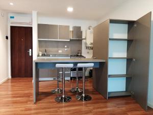 een keuken met een aanrecht en krukken in een kamer bij Departamentos DSM in Necochea