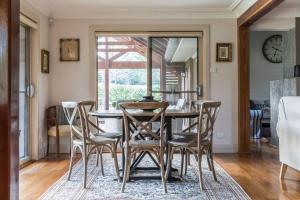 a dining room with a table and chairs at Stonelinks House sleeping 12 in Leura