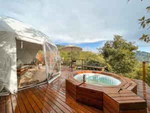 a hot tub on a deck with a igloo at Nazca Glamping in Villamaría