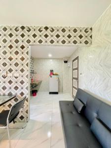 a living room with a blue couch and a refrigerator at โรงแรมเรือนคุณเล็ก กานต์สินี in Ban Tha Pho