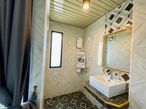 a bathroom with a sink and a mirror at โรงแรมเรือนคุณเล็ก กานต์สินี in Ban Tha Pho