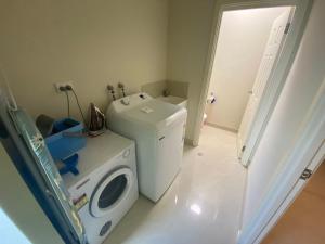 Unit 46 Seafront Estate في جوريين باي: غرفة غسيل مع غسالة ملابس وغسالة