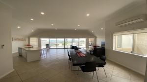 a large living room with a table and a kitchen at The Beach House in Jurien Bay