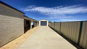 a walkway with a white door on the side of a building at Maniki Gardens, 9 Maniki Gardens in Jurien Bay