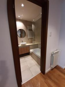 een badkamer met een bad, een wastafel en een spiegel bij Departamentos DSM in Necochea +25 foto's