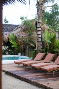 a row of lounge chairs next to a swimming pool at Happiness Beach Resort Siargao in General Luna