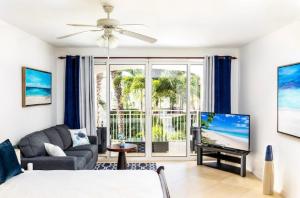 uma sala de estar com um sofá e uma televisão de ecrã plano em La Vista Azul - Lovely Spacious Condo close to Grace Bay - Free Wi-Fi em Turtle Cove