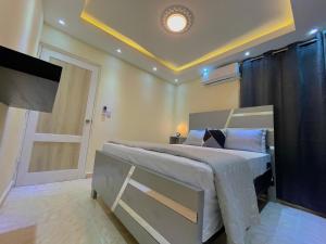 a bedroom with a bed with a door and a television at Apartamento en Residencial Privado in San Isidro