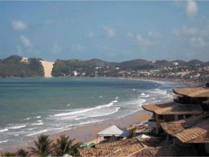 a view of a beach with houses and the ocean at Atlântico Flat - Apto 004 in Natal
