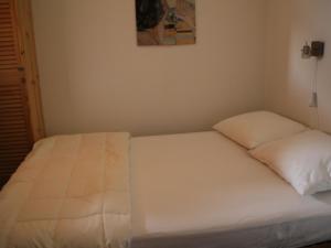 シャテルにあるAppartement Châtel, 2 pièces, 5 personnes - FR-1-200-220の白い枕2つが備わるドミトリールームのベッド1台分です。