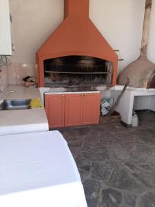 a room with a fireplace with a bed and a sink at BenjaCha in Cerrillos