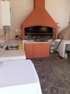 a kitchen with a fireplace and a sink in a room at BenjaCha in Cerrillos