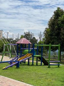 a playground with a slide and a play structure at Finca Don Matías in Melgar